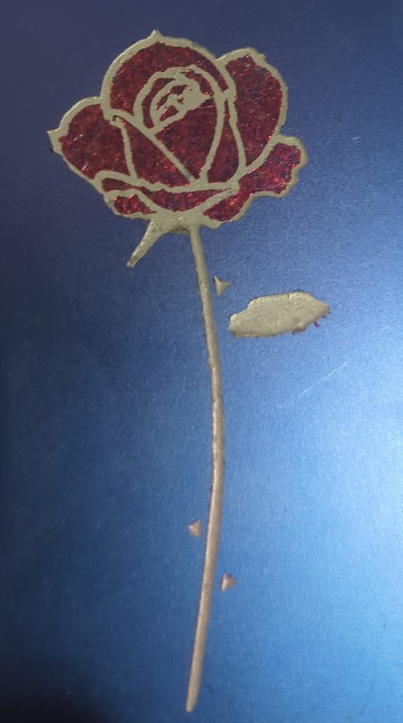 A rose with grey paint stem and red metal leaf petals on a blue background